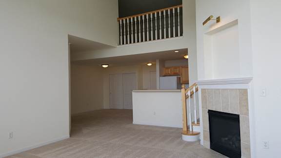 A living room with a fireplace and a balcony.