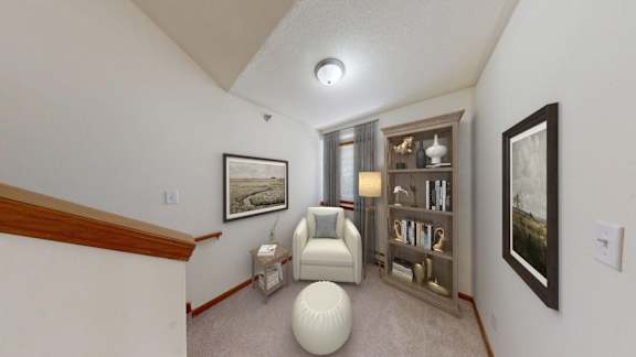A living room with a white chair and a bookshelf.