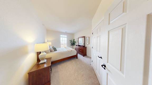 A bedroom with a bed, nightstand, and lamp.