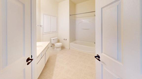 A white bathroom with a toilet, sink, and bathtub.