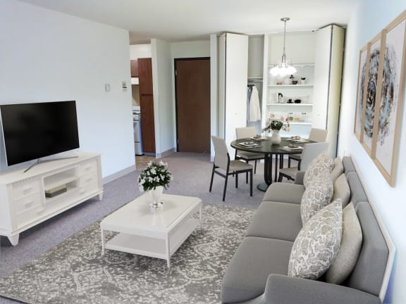a living room and dining room with a couch and a television