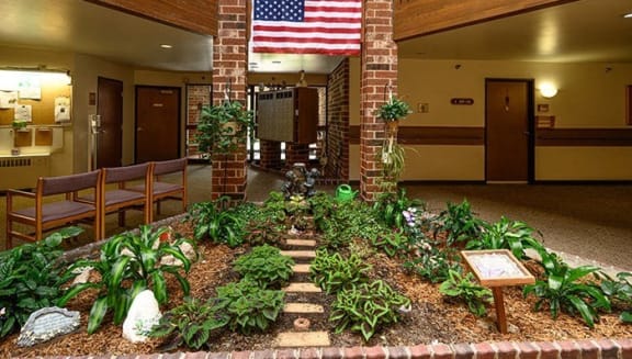 an indoor garden in a lobby with a flag