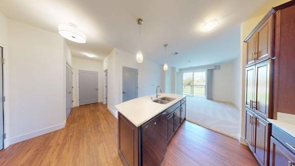 A kitchen with wooden floors and white walls.