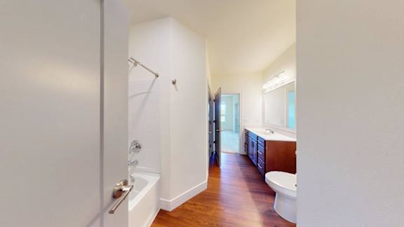 A white bathroom with a tub and toilet.