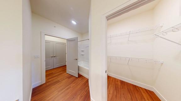 A hallway with a white door and a white wall.