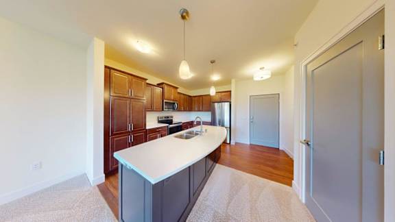 A kitchen with wooden cabinets and a white island.