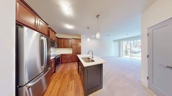 A kitchen with wooden floors and stainless steel appliances.