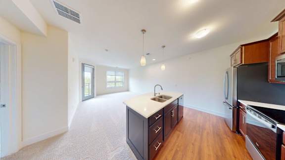 A kitchen with wooden cabinets and a black fridge.