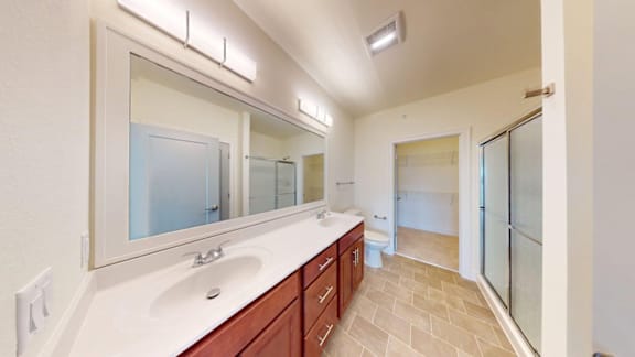A bathroom with a sink, mirror, and shower.