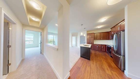 A kitchen with wooden floors and stainless steel appliances.