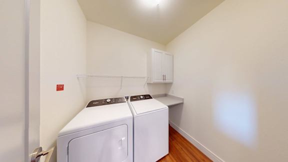 A small laundry room with a washer and dryer.