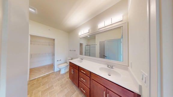 A bathroom with a sink, toilet, and mirror.