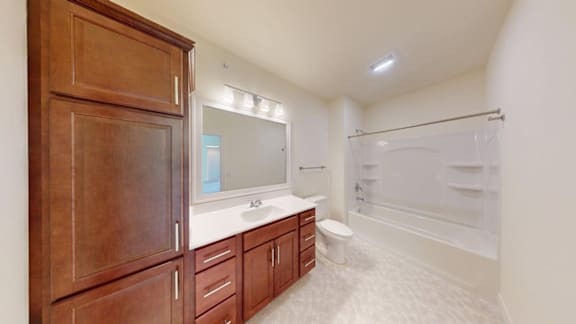 A bathroom with a toilet, sink, and mirror.