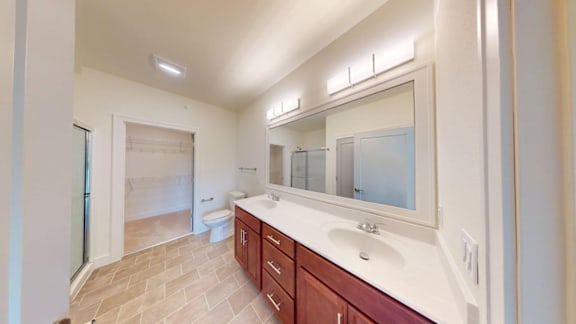 A bathroom with a sink, mirror, and shower.