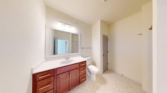 A bathroom with a white countertop and a white toilet.