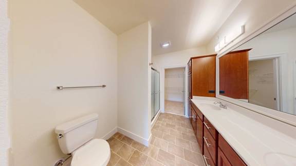A bathroom with a toilet, sink, and mirror.