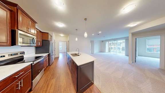A spacious kitchen with dark wood cabinets and a white countertop.
