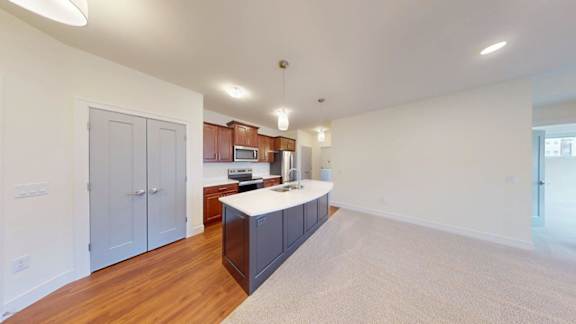 A kitchen with a white countertop and wooden cabinets.