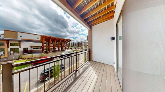 A balcony with a wooden floor and a metal railing.