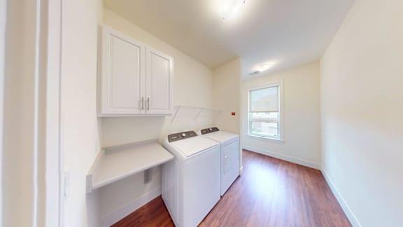 A kitchen with white cabinets and a window.