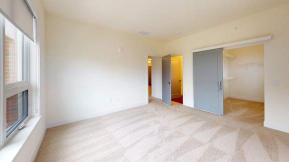 A room with a carpeted floor and a sliding door.