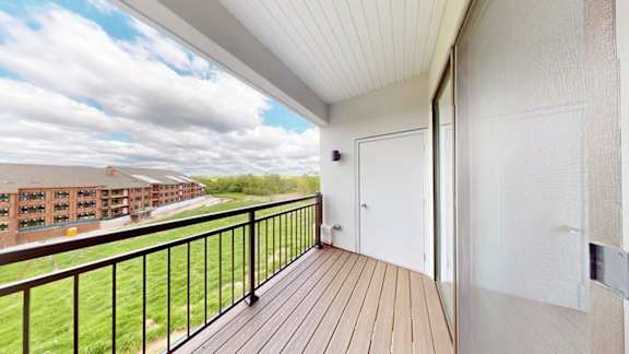 A balcony with a white door and a black railing.
