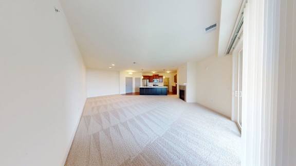 A long hallway with a carpeted floor and white walls.