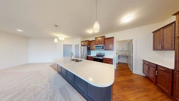 A kitchen with a white countertop and wooden cabinets.