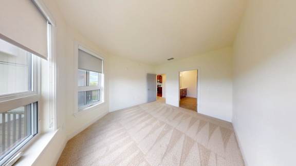 A room with a carpeted floor and a door at the end.