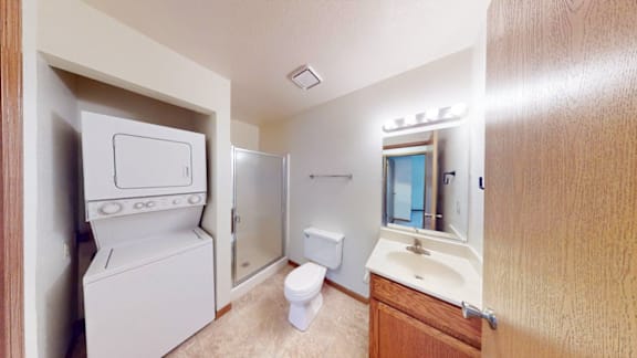 A small bathroom with a toilet, sink, and a small refrigerator.