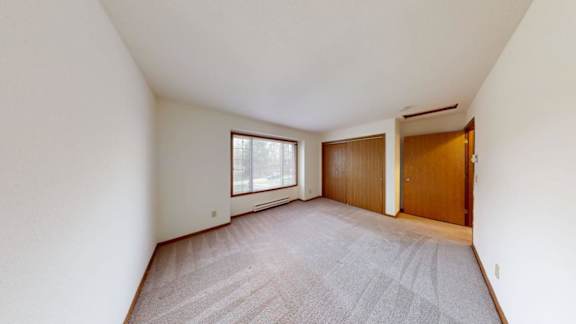 A room with a carpeted floor and a window.