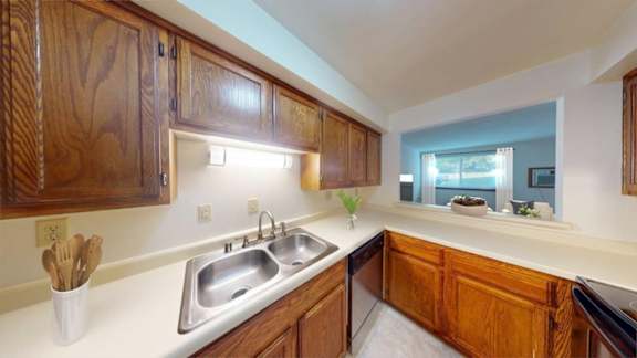 A kitchen with wooden cabinets and a stainless steel sink.