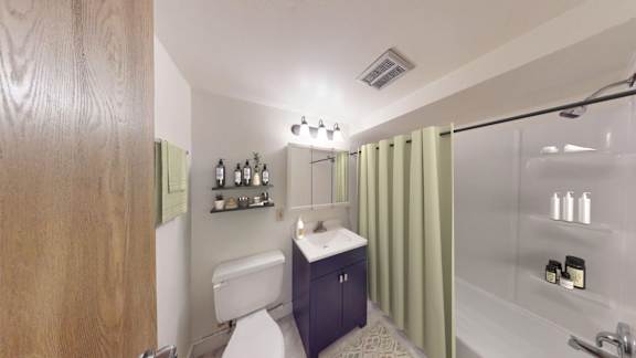 A bathroom with a toilet, sink, and shower.