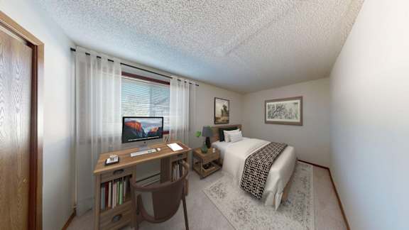 A bedroom with a bed, desk, and chair.