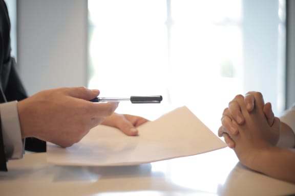 a man and a woman sitting at a table with a piece of paper and a pen  at Poplar Creek Apartments, Wisconsin