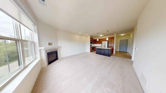 A spacious living room with a fireplace and a television.