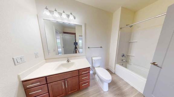 A bathroom with a sink, toilet, and shower.