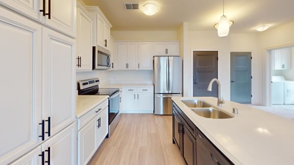 a large kitchen with white cabinets and stainless steel appliances