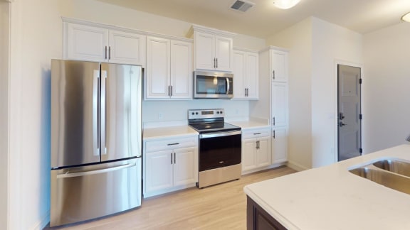 a kitchen with stainless steel appliances and white cabinets
