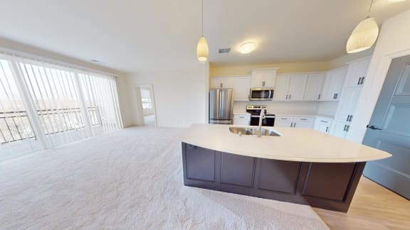 an open kitchen and living room with a white counter top