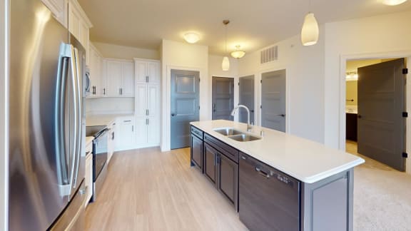 a large kitchen with stainless steel appliances and white counter tops