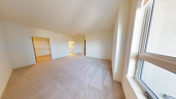 the living room and dining room of an apartment with a large window