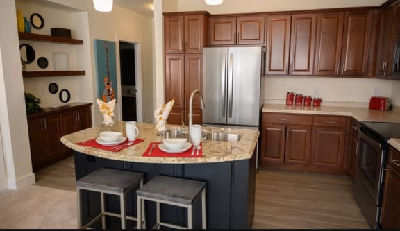 Kitchen with a large island with a granite countertop  at Poplar Creek Apartments, Brookfield, WI