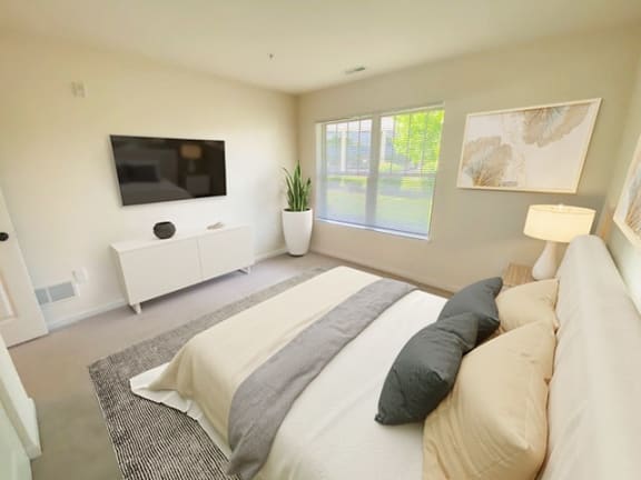 a bedroom with a bed and a television on the wall