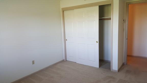 A white door is in a room with a tan carpet.