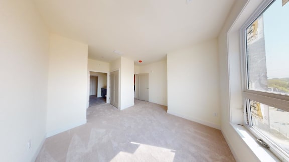a living room with a large window and white walls