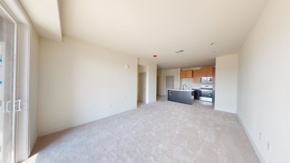 a large empty living room with a kitchen in it