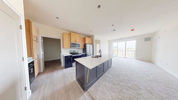 a large kitchen and living room with an island in the middle