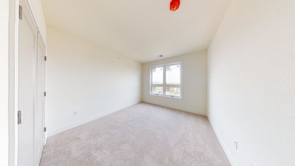 an empty living room with a window and a door