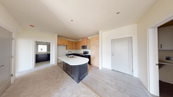 a kitchen with a white counter top in a large empty room